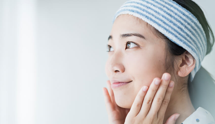  a woman applying face toner